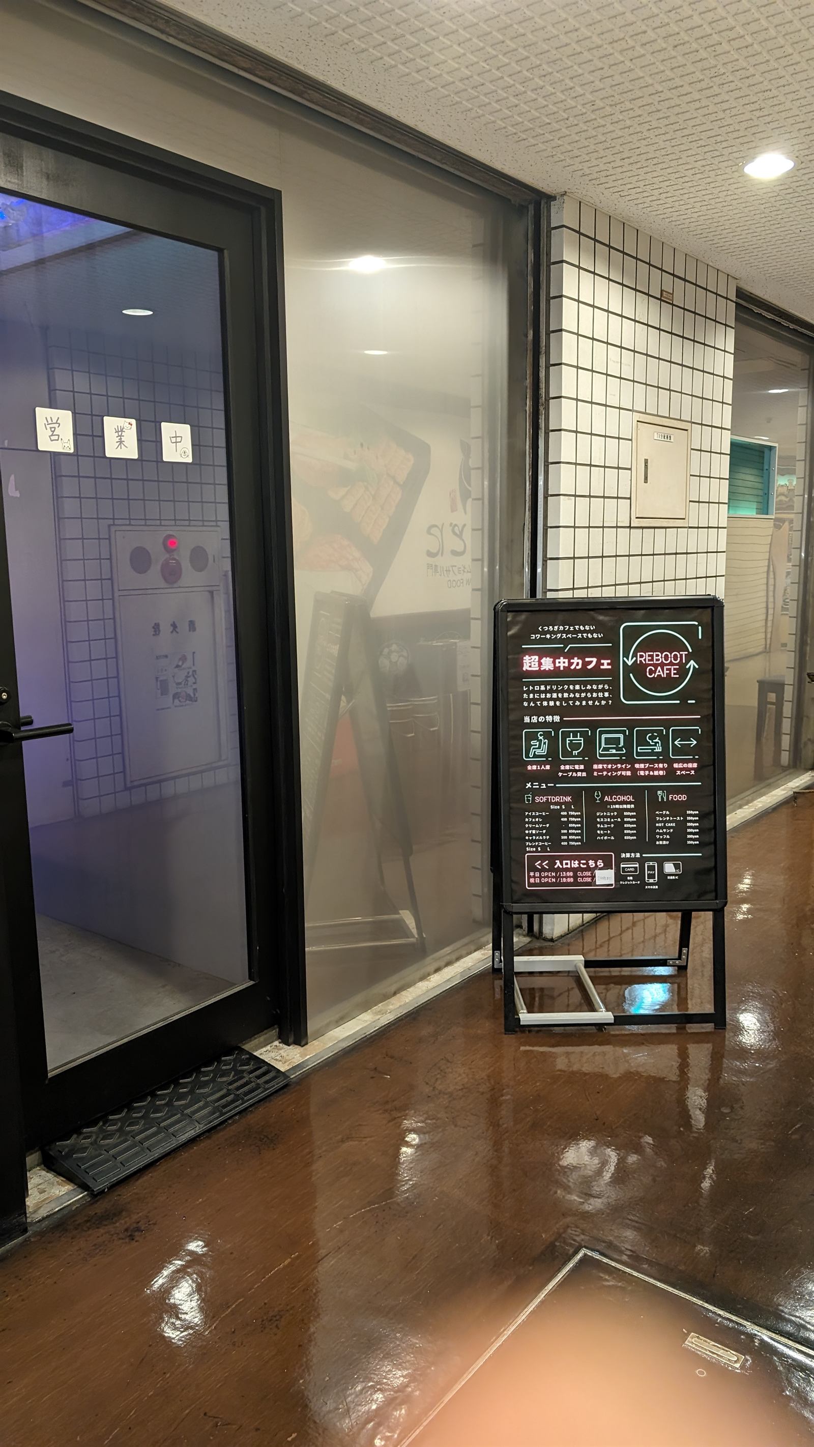 地下1階の店舗のガラス扉と黒い立て看板