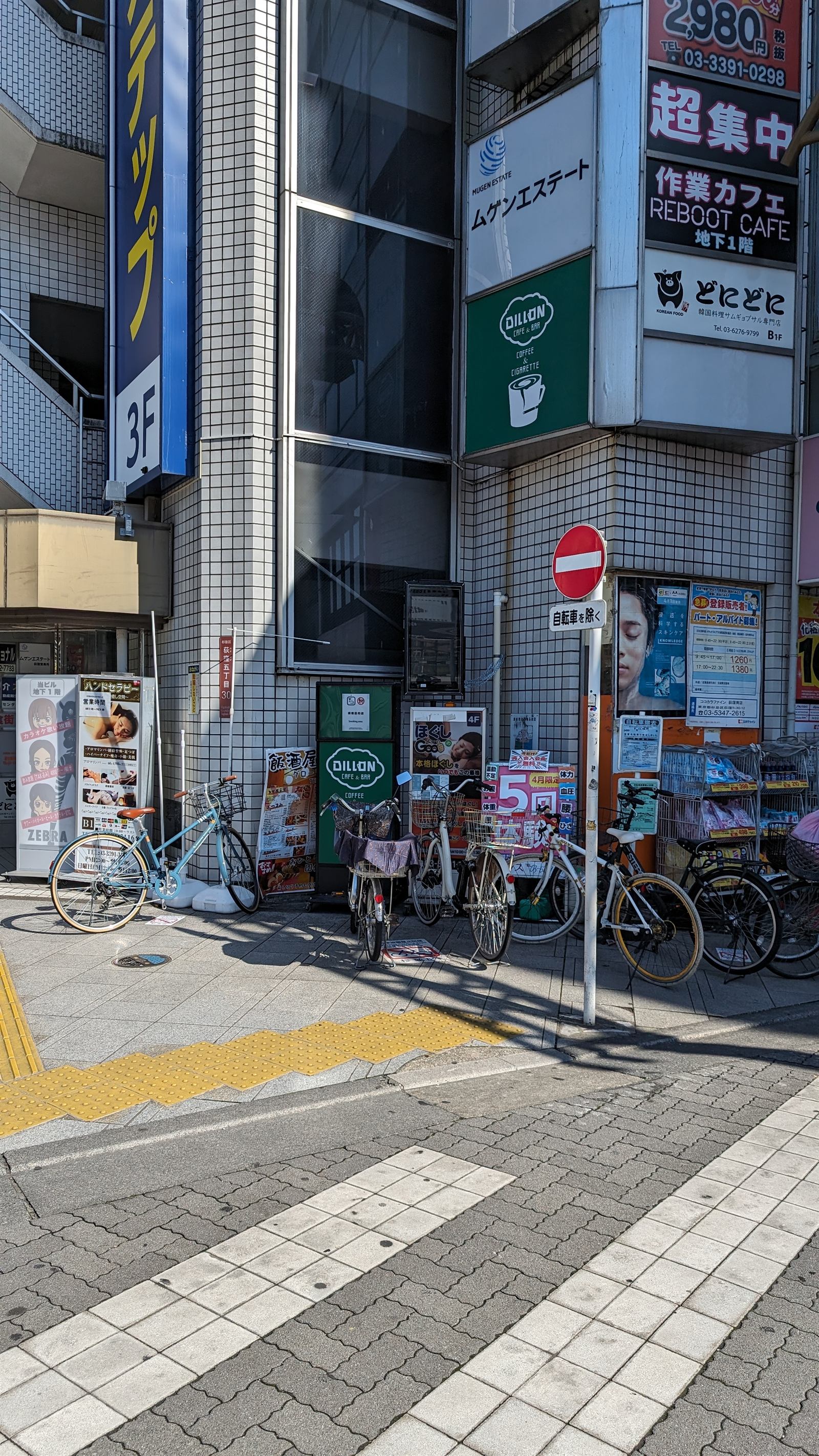 ビルの壁にある「作業カフェ REBOOT CAFE 地下1階」の縦長の看板